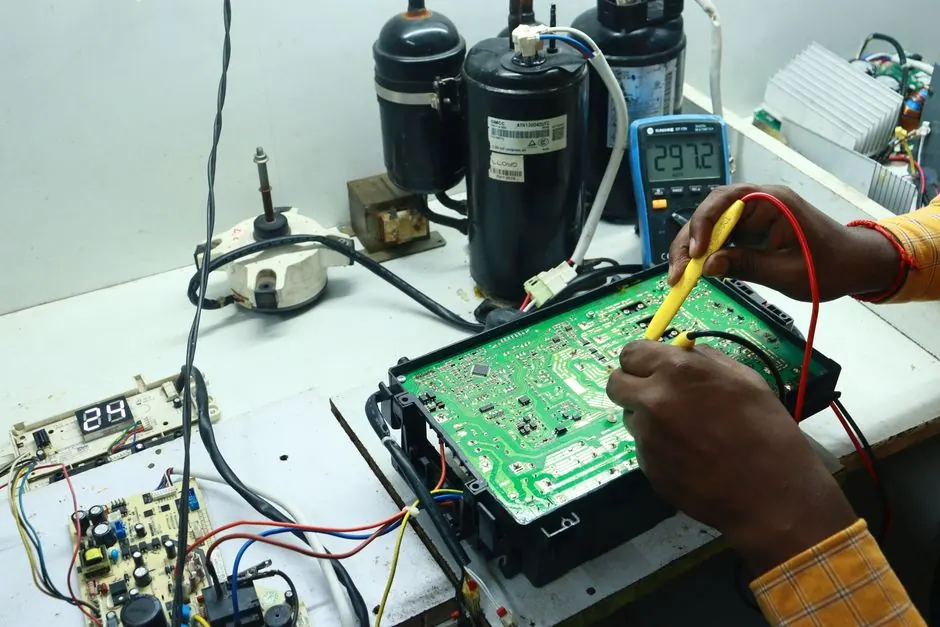 Technician working on AC PCB with tools and equipment, captured in Spring Hil workshop.
